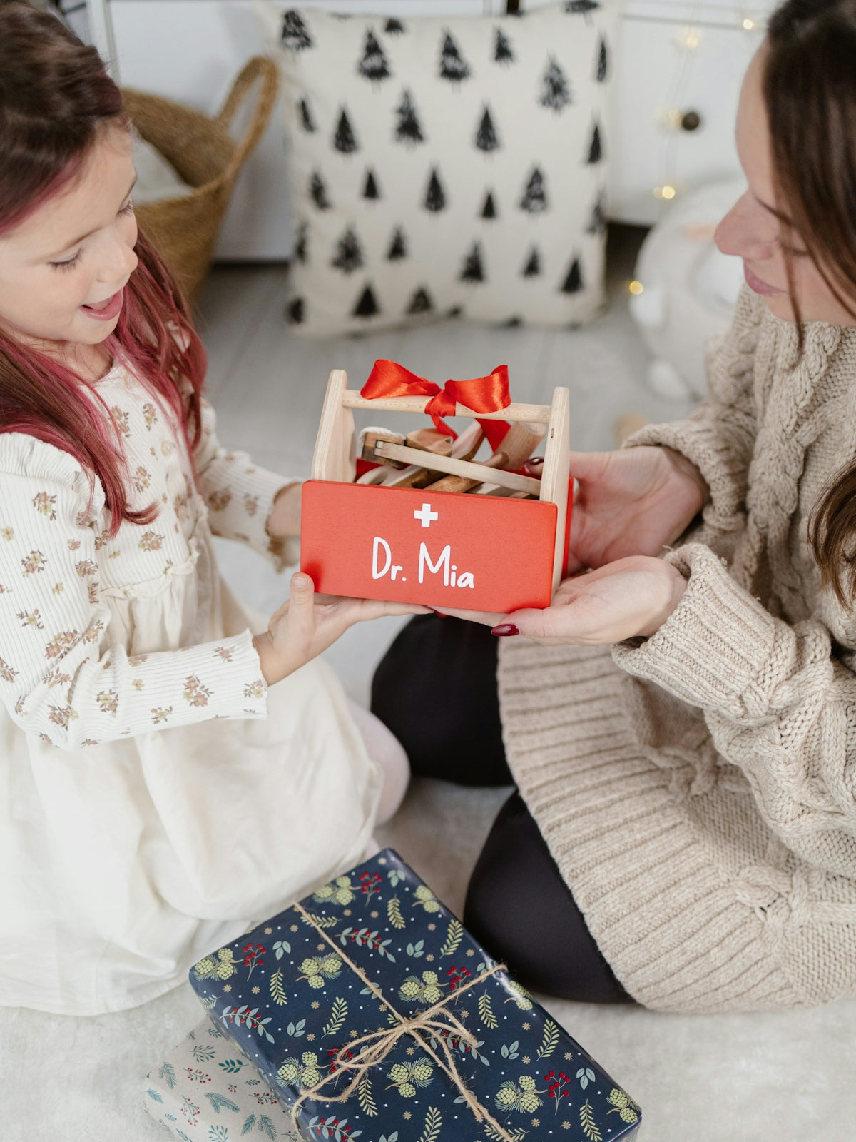 A woman and a little girl sitting on the floor